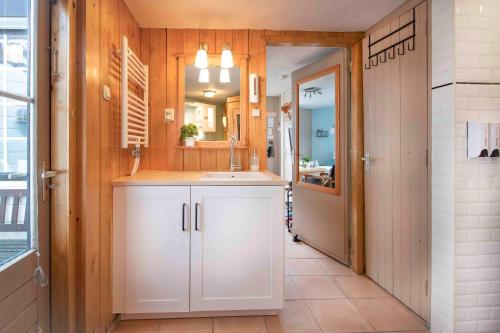 een badkamer met een wastafel en een spiegel bij B&B Noordzee-kerstdeco-Sauna-Strand7km-Kennemerduinen in Driehuis