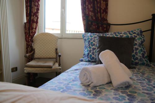 Casa di Amici - Garbatella في روما: غرفة نوم عليها سرير وفوط