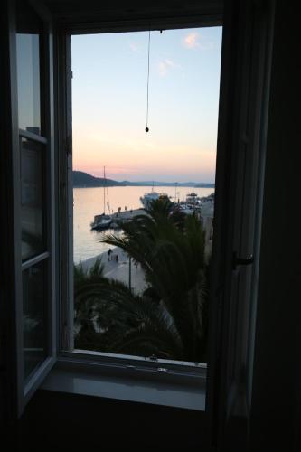 an open window with a view of the ocean at Apartments and Rooms Jospino in Mali Lošinj