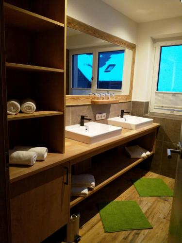 een badkamer met 2 wastafels en een grote spiegel bij Apartments Haufhof , Haus im Ennstal bei Schladming in Haus im Ennstal