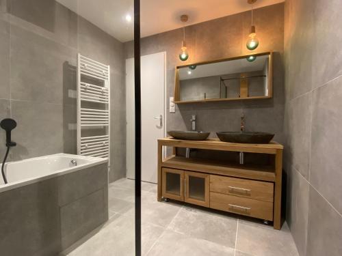 une salle de bain avec deux lavabos, une baignoire et un miroir dans l'établissement Villa les Portes de Provence, à Sauzet