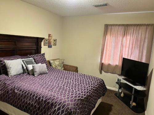 a bedroom with a purple bed and a television at Quiet and Beautiful home in Montgomery
