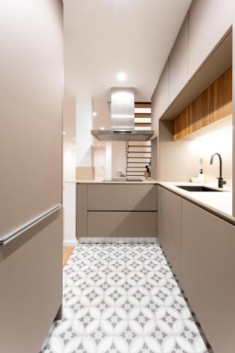 a kitchen with white cabinets and a tile floor at Casa Dona Adelaide in Vila do Conde