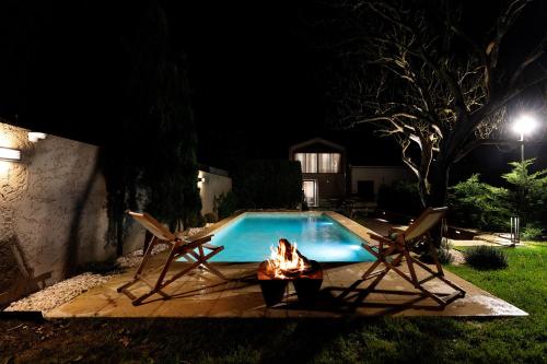 a woman is laying in front of a swimming pool at night at Casa Dona Adelaide in Vila do Conde