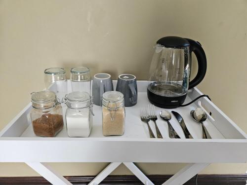 a white shelf with jars and utensils on it at The Hide in Sandton 2 in Sandton
