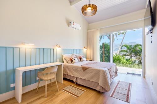 a bedroom with a bed and a large window at “Casa de alto padrão com ampla vista para o mar.” in Ubatuba