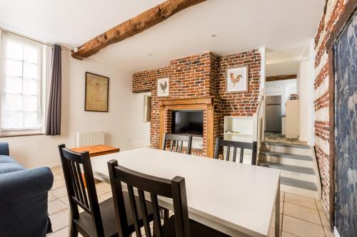 une salle à manger et un salon avec une table et des chaises blanches dans l'établissement Maison Juliette, maison à la campagne, à Comines