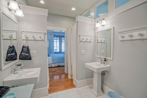 a white bathroom with two sinks and a mirror at Habersham Retreat on Abbey Row in Beaufort