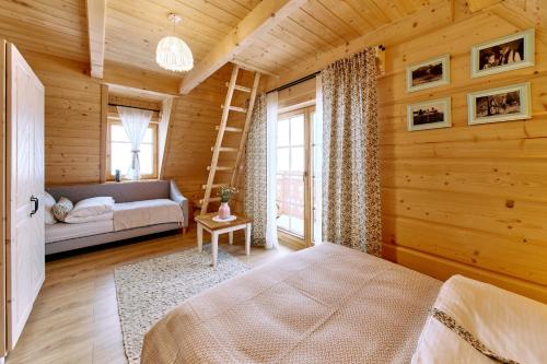 a bedroom with a bed and a ladder in a room at Marusina Chalets in Szaflary
