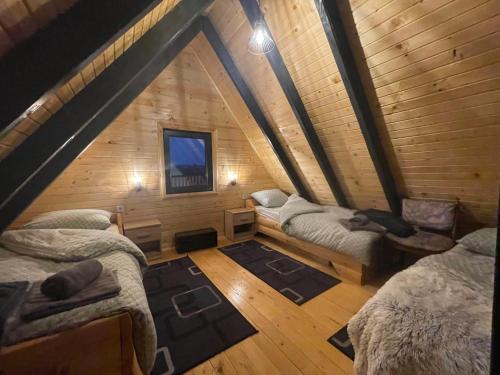 a room with three beds in a wooden cabin at Vikendica A&J in Blidinje