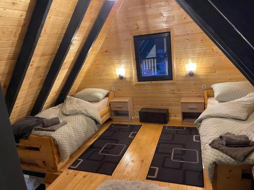 a room with two beds in a log cabin at Vikendica Bulat in Blidinje