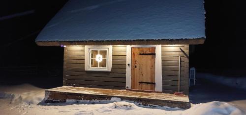 ein kleines Haus mit einem Fenster und einer Tür im Schnee in der Unterkunft Leeotsa Talu Ait 