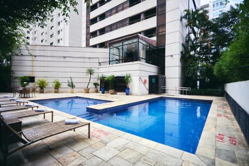 uma piscina em frente a um edifício em Quality Paulista (São Paulo, Jardins) em São Paulo