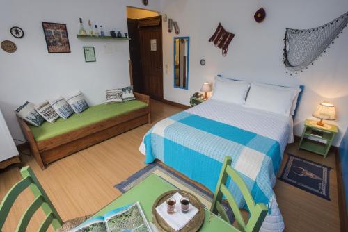 1 dormitorio con cama y sofá en Pousada Old Beach, en Florianópolis