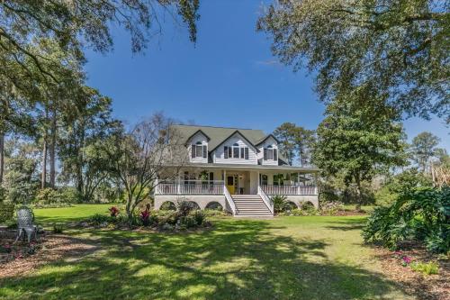 an exterior view of a large white house with trees at Private Retreat on Deep Water overlooking Jenkins Creek in St. Helena Island