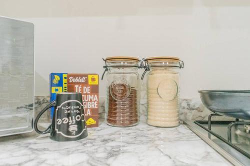 three glass jars on a counter next to a stove at LOFT Lujoso y Moderno Con Cama King en Centrico Historico in Durango