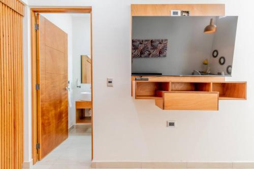 a bathroom with a television on a wall next to a hallway at LOFT Lujoso y Moderno Con Cama King en Centrico Historico in Durango