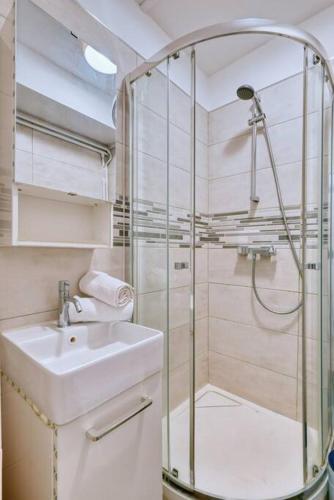 une salle de bain avec une douche en verre et un lavabo dans l'établissement prado studio à 5 min des plages, à Marseille