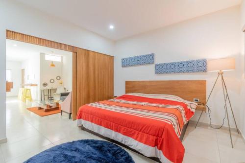 1 dormitorio con 1 cama con manta roja en LOFT Lujoso y Moderno Con Cama King en Centrico Historico, en Durango