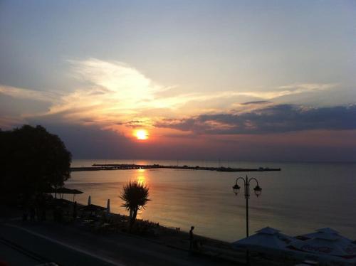 a sunset over a body of water with at Sea and Sun Luxury apartment in Neoi Epivates