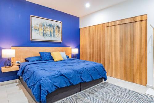 une chambre bleue avec un grand lit et une tête de lit en bois dans l'établissement LOFT El Azul en Centro Historico con Cama King, à Durango