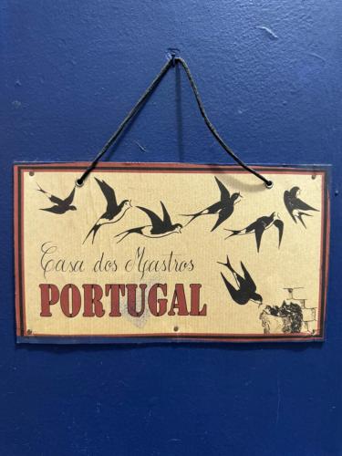 リスボンにあるCasa dos Mastrosの青い壁に鳥がぶら下がっている