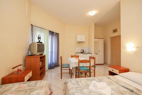 Cette chambre comprend un lit, une table et une télévision. dans l'établissement Beachfront apartments Jermen, à Sukošan