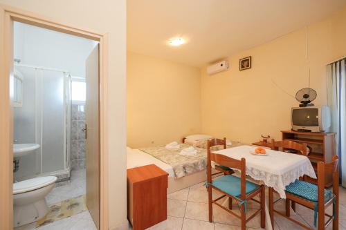a small room with a table and a bathroom at Beachfront apartments Jermen in Sukošan