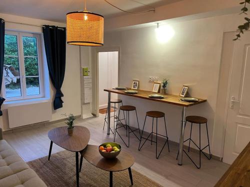a living room with a kitchen with a table and stools at La Mezzavilla in Nuits-Saint-Georges