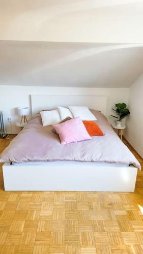 ein Bett mit vier Kissen in einem Schlafzimmer in der Unterkunft DG Links -Wunderschöne 40m² große City Wohnung nähe Salzburg in Freilassing