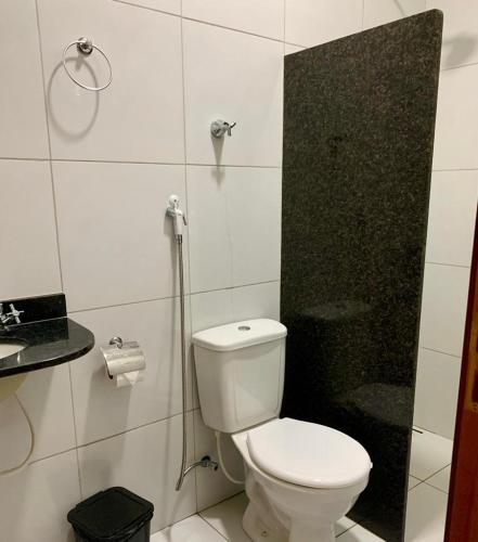 een witte badkamer met een toilet en een douche bij POUSADA NOVO HORIZONTE in Martins