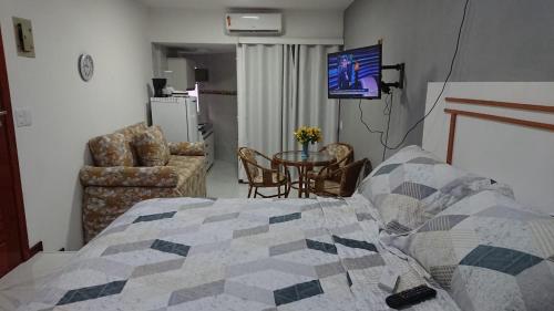 a bedroom with a bed and a table and a tv at FLAT O POINT do CARNAVAL do FAROL da BARRA in Salvador
