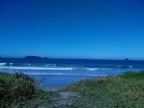 uma praia com o oceano e um céu azul em AP praia Itaguaçu São Chico em São Francisco do Sul
