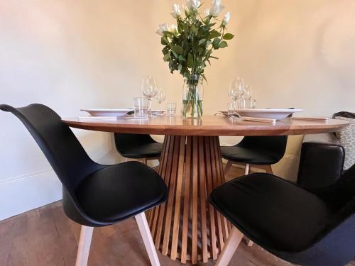 une table en bois avec des chaises et un vase de fleurs dans l'établissement Ça se passe ici, à Dijon