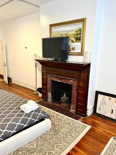 a living room with a fireplace and a flat screen tv at Legacy - Spring Garden University City in Philadelphia