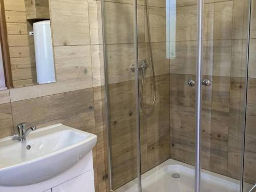 a bathroom with a glass shower and a sink at Spiska Chatka in Kacwin