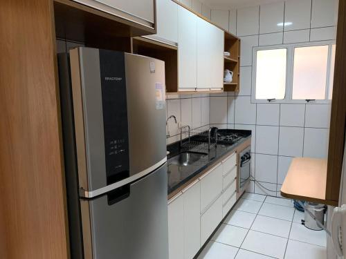 a kitchen with a refrigerator and a sink at Apê Carla Valéria in Ubatuba