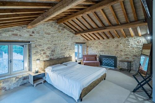 a bedroom with a bed and a stone wall at Anfihouse - Assisi Relais in Assisi
