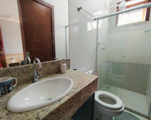a bathroom with a sink and a toilet and a shower at Casa da alegria 4 quartos centro histórico in Itaparica