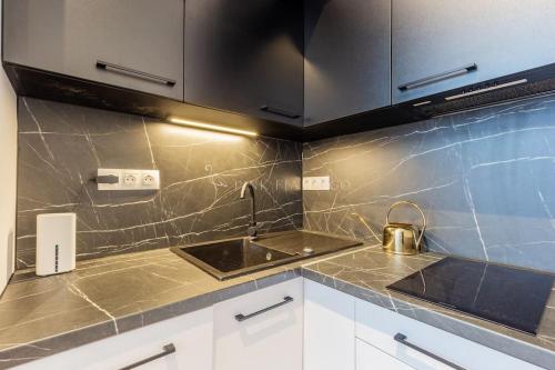 a kitchen with a sink and a tea kettle at Elegant Stay Near Hungarian Museum by Pink Flamingo in Budapest