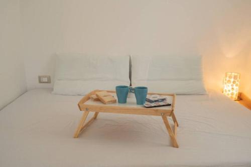 een tafel met twee blauwe kopjes bovenop een bed bij Angolo Vista Mare in Ostuni