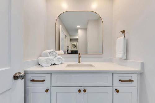 a white bathroom with a sink and a mirror at Downtown Condo Walk To Mercedes Benz Stadium in Atlanta