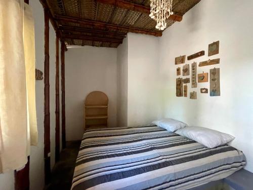 a bedroom with a bed with a striped blanket at Naif habitaciones in Máncora
