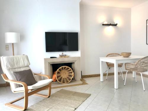 a living room with a fireplace and a tv at Mike Beach House in Costa da Caparica