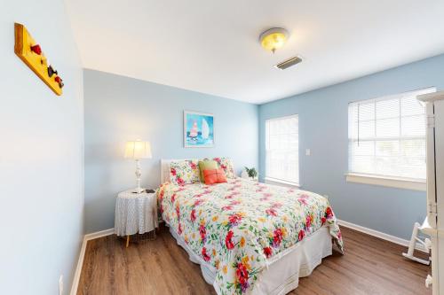 a bedroom with a bed with a floral bedspread at Guest House 2340 in Dauphin Island