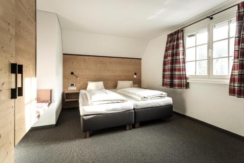 1 dormitorio con 2 camas y ventana en Hotel-Gasthof Löwen en Feldkirch