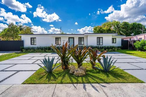 a white house with plants in the yard at Casa De Miller in Tamiami
