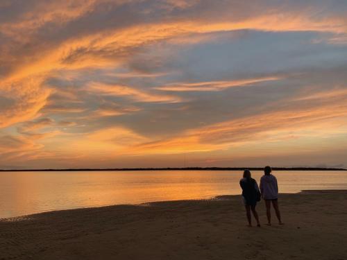 two people standing on the beach watching the sunset at Beach Access - Golf Cart Included - Views of the Marsh and Harbor River - Sleeps 10 in Harbor Island