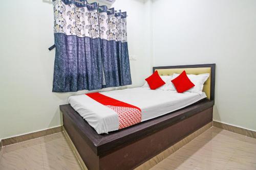 Schlafzimmer mit einem Bett mit roten und blauen Vorhängen in der Unterkunft OYO Flagship Hotel Mh31 in Nagpur