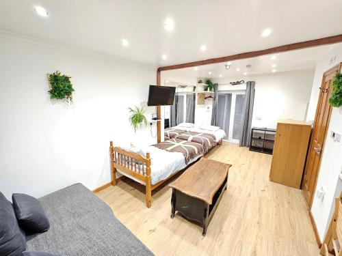 a living room with two beds and a couch at Studio apartment, TV, WiFi Kitchen Parking, Wembley Elizabeth Line in Northolt